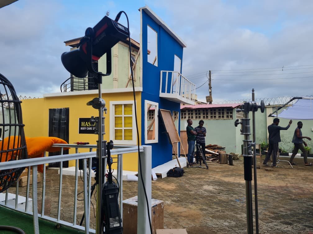 Crew building a blue and yellow exterior set in the ContentGram Studios Africa yard